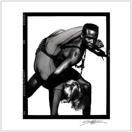 A man and woman in an intimate dance pose, featuring dynamic movement and layered attire.