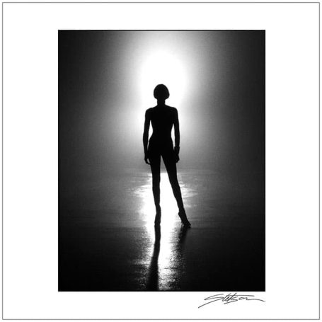 Silhouette of a person standing against a bright, glowing background.