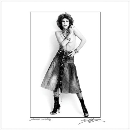 A stylish woman poses confidently in a short skirt and high-heeled boots.
