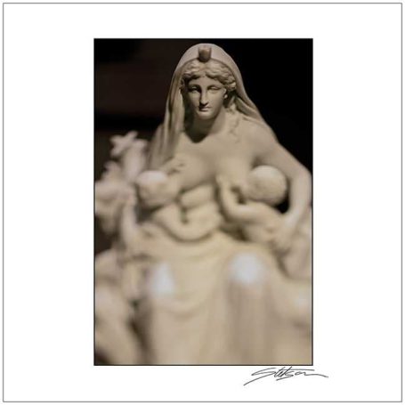 A detailed statue of a woman with children, exuding maternal care and tenderness.