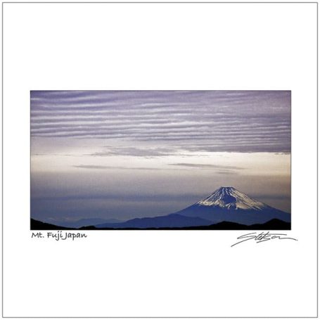 Snow-capped mountain under a cloudy sky, with a serene landscape in the foreground.