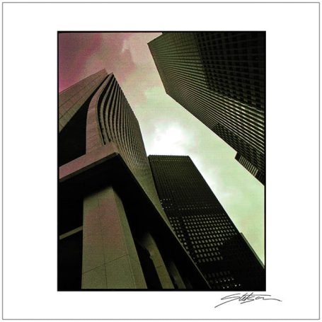 Abstract view of tall, modern skyscrapers against a cloudy sky.