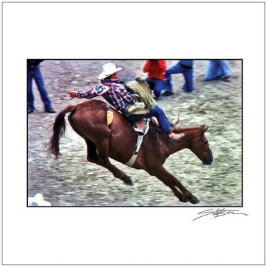 Cowboy riding a bucking horse at a rodeo event.