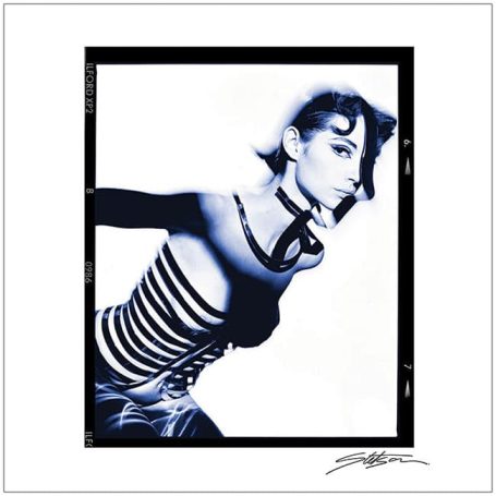 A woman in a striped top posed dynamically against a stark black and white background.