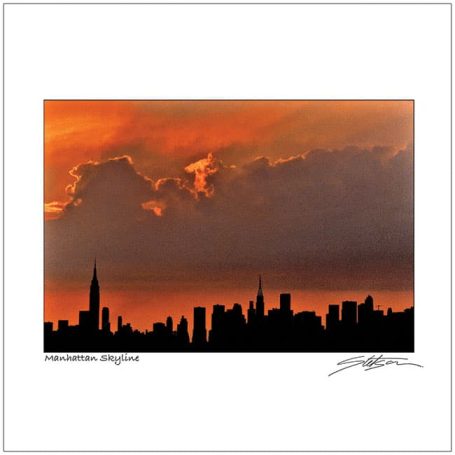 Silhouette of a city skyline against a vibrant sunset sky with clouds.
