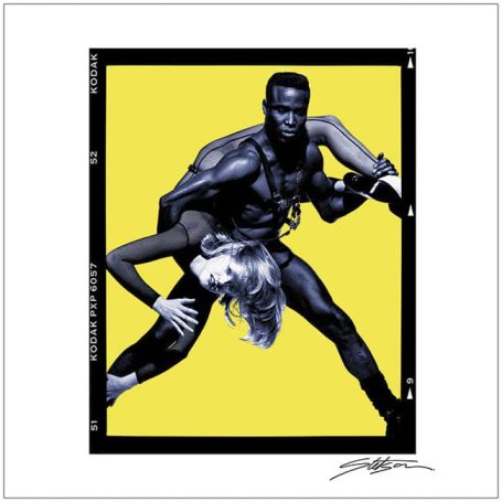 A dynamic pose featuring a muscular man supporting a woman against a bright yellow background.