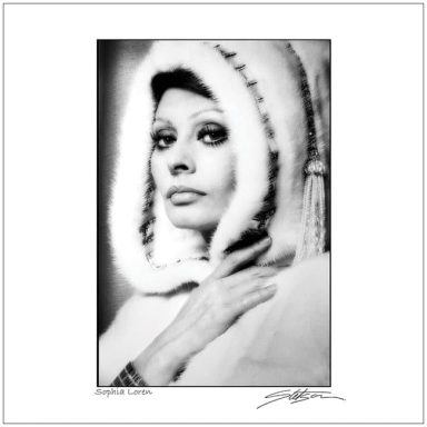Black and white portrait of a woman in a hooded garment, striking a contemplative pose.