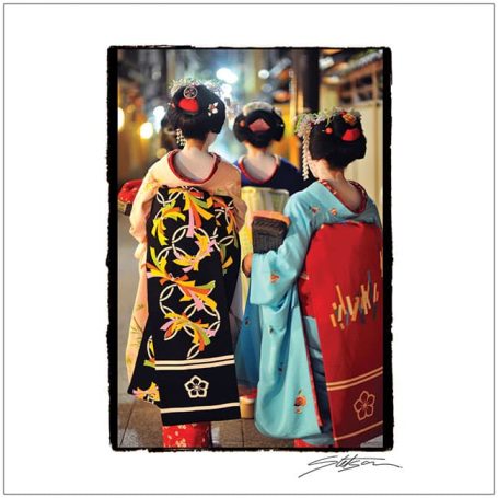 Two women in traditional kimonos walking down a narrow street in a historic setting.