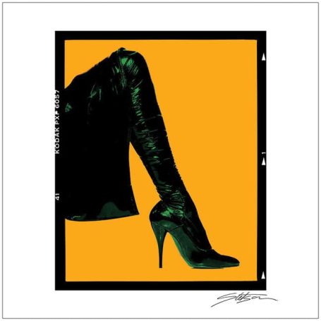 A close-up of a high-heeled shoe and described patterned stocking against an orange background.