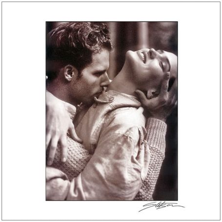 A romantic black and white portrait of a couple in a tender embrace.