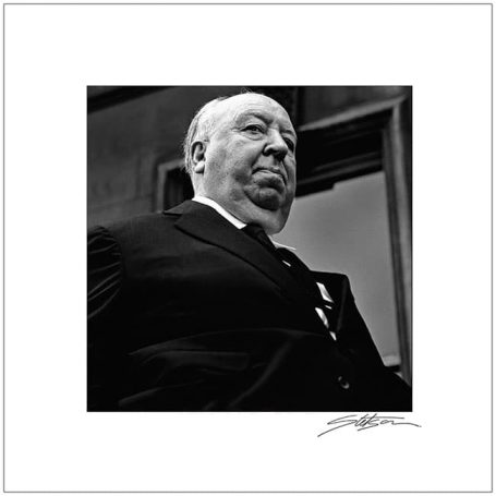 Black and white portrait of a man in a suit, looking upward with a contemplative expression.