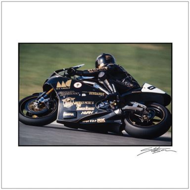 A black racing motorcycle leaning into a curve with a rider in black leathers.