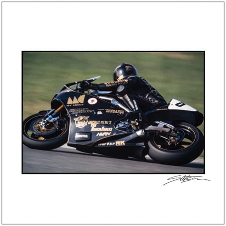 A black racing motorcycle leaning into a curve with a rider in black leathers.
