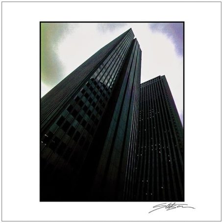 Tall modern skyscrapers against a cloudy sky, viewed from below.