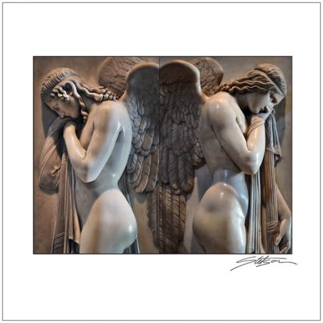 Two grieving angel sculptures with detailed wings and sorrowful expressions.