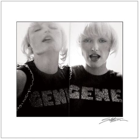 Black and white selfie of a person with short blonde hair wearing a t-shirt that says "GENE."