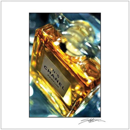 Close-up of a luxurious Chanel perfume bottle with a golden liquid.