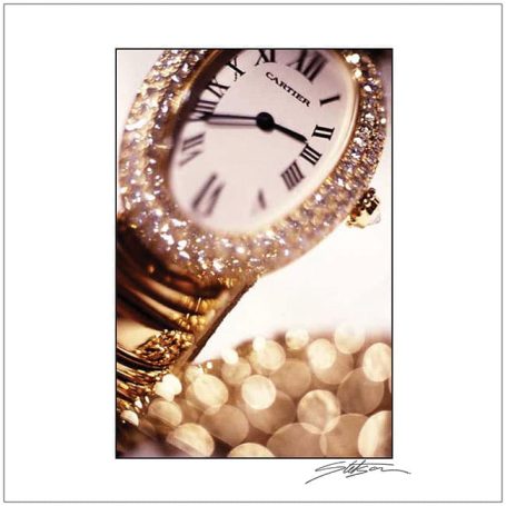 Gold watch with a sparkling bezel and Roman numerals, resting on a glittering background.