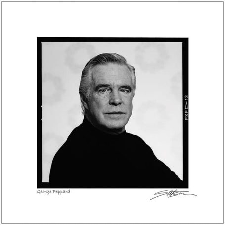 Portrait of a man with silver hair wearing a black turtleneck, looking directly at the camera.