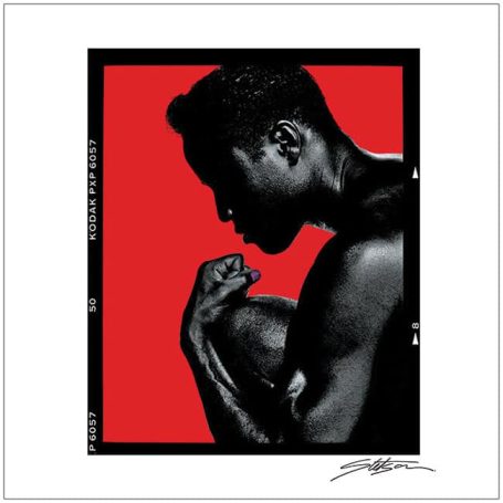 Silhouette of a man flexing his arm against a bold red background.