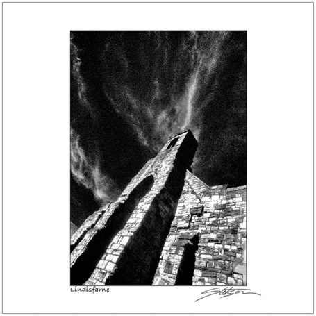 Dramatic view of a stone structure against a cloudy sky in black and white.