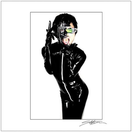Person in a glossy black outfit with sunglasses and a playful pose.