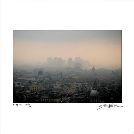 A hazy urban skyline with buildings partially obscured by fog.