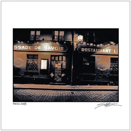 A dimly lit restaurant with a vintage sign and cobblestone street in front.