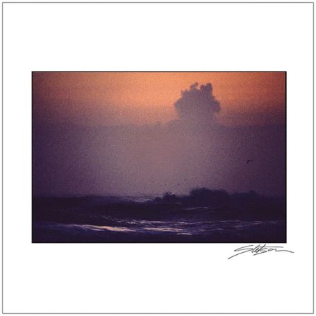 A hazy sunrise over the ocean with soft purple and orange hues.