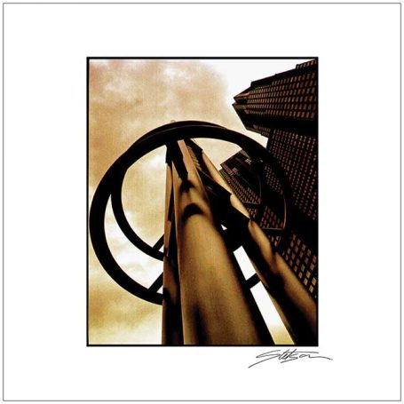 Close-up of a circular metal structure against a cloudy sky and buildings.