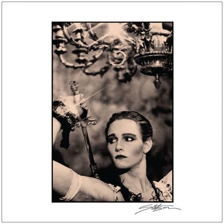 A dramatic portrait of a woman holding a sword, gazing intensely upwards.